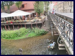 Uzupis. The Vilnia River borders to Uzupis from the Old Town. Note the man that sits aboe the river, opposite the café.